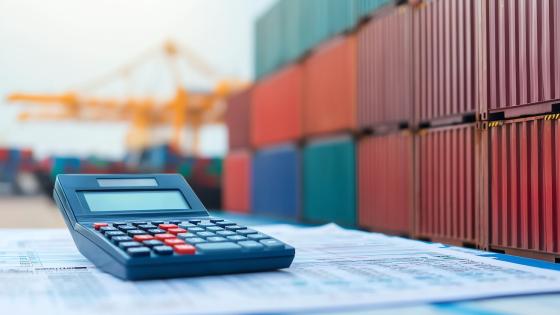 Calculator in front of shipping containers