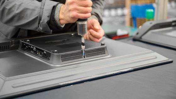 Worker assembles television housing