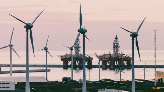Wind turbines in front of oil rigs off coast