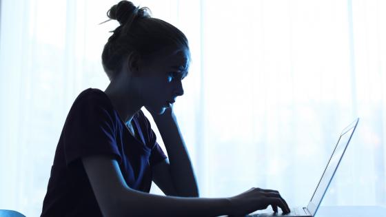 Upset teenage girl using laptop