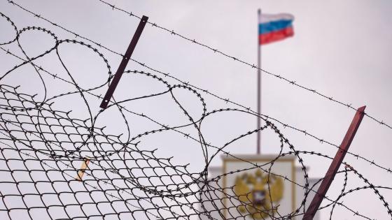 Russian flag on building behind barbed wire