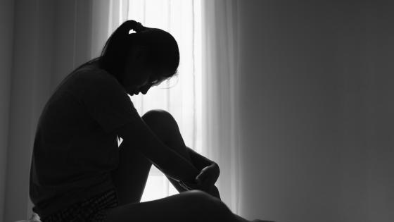 Woman sitting on floor in shadows