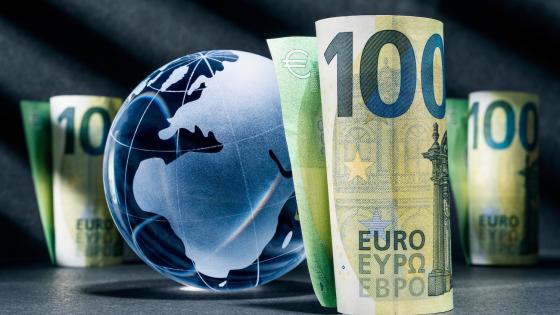 Blue globe and rolled up euro notes