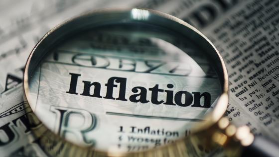 Magnifying Glass on Newspaper Word 'Inflation'