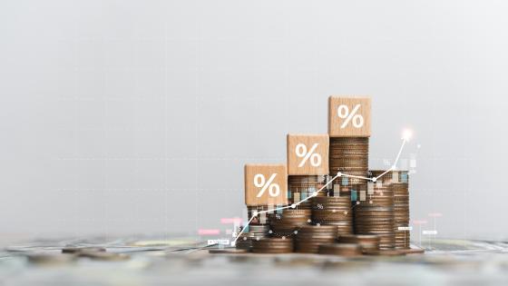 Stack of coins with percentage symbols on wooden cubes