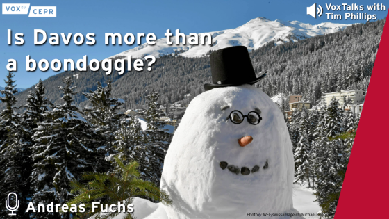 A promotional graphic for the CEPR VoxTalks podcast episode titled "Is Davos more than a boondoggle?" with guest Andreas Fuchs. The image features a large smiling snowman wearing round glasses and a black top hat, set against a snowy alpine backdrop with pine trees and the town of Davos nestled below snow-covered mountains. CEPR and VoxEU logos appear in the top corners, and a microphone icon is next to the speaker’s name at the bottom left.